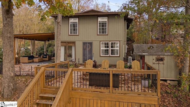 rear view of house featuring outdoor lounge area, ceiling fan, a shed, and a deck