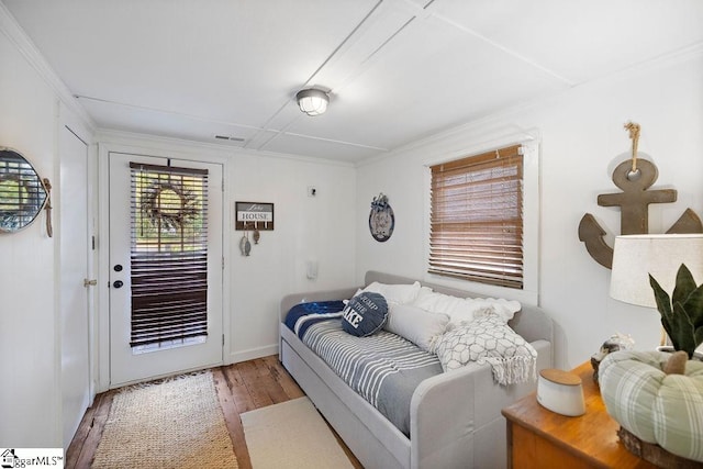 bedroom featuring access to outside, light hardwood / wood-style floors, and crown molding