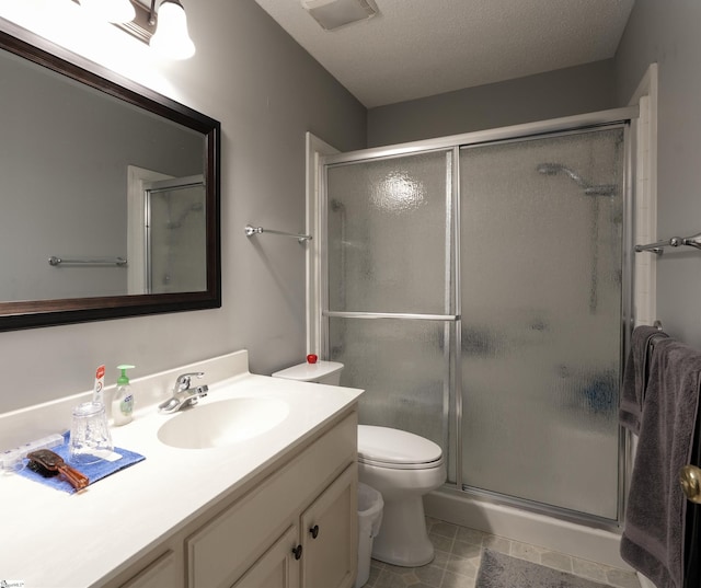 bathroom featuring walk in shower, vanity, a textured ceiling, and toilet