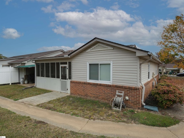 view of front of property featuring a front lawn and a sunroom