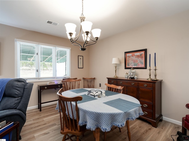 dining space with a chandelier and light hardwood / wood-style flooring