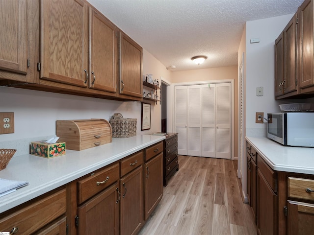 kitchen featuring a textured ceiling and light hardwood / wood-style flooring