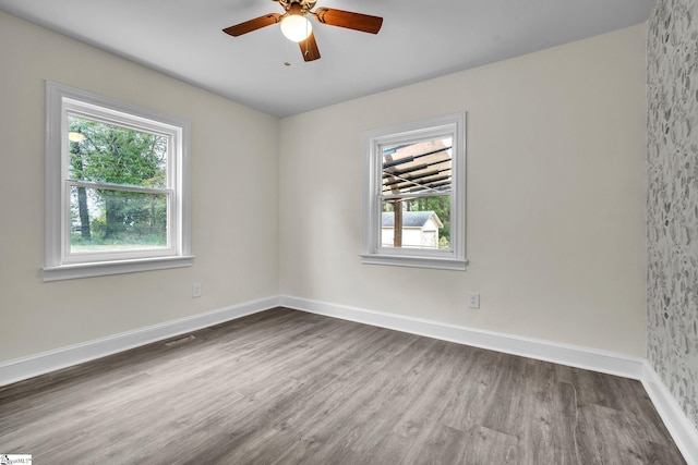 unfurnished room with ceiling fan, hardwood / wood-style floors, and a wealth of natural light