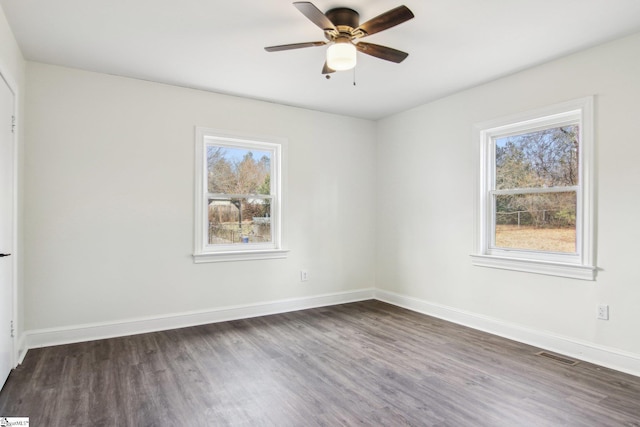 spare room with plenty of natural light, dark wood-type flooring, and ceiling fan