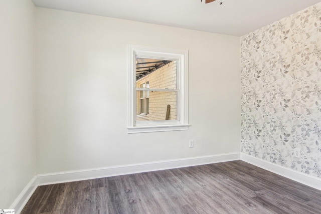 empty room with dark hardwood / wood-style floors and ceiling fan