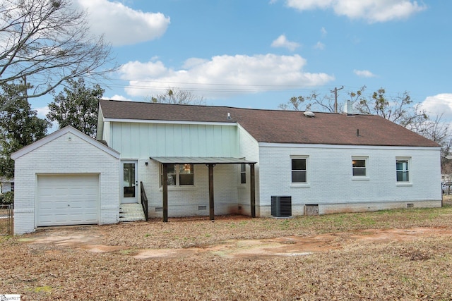 back of house featuring central AC unit and a garage