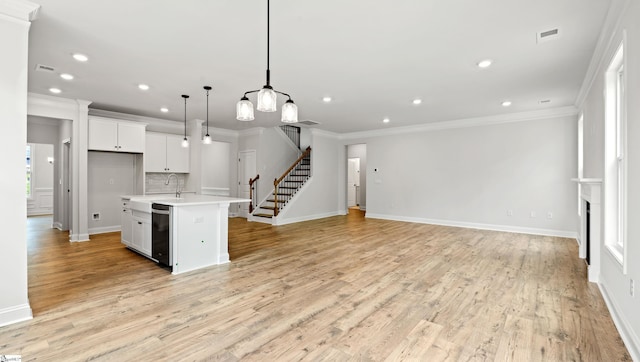 kitchen featuring crown molding, dishwasher, light countertops, recessed lighting, and open floor plan