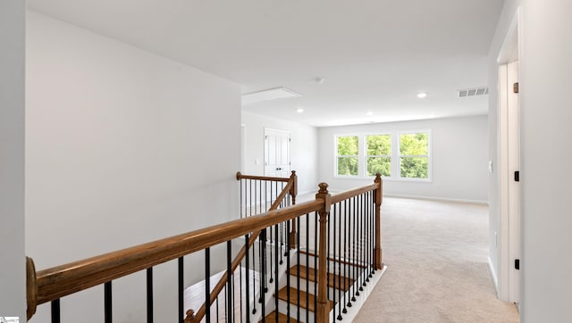 hall with an upstairs landing, light colored carpet, baseboards, and recessed lighting