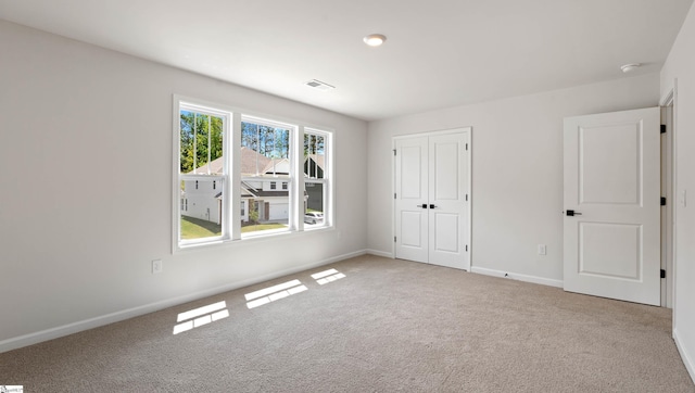 unfurnished bedroom with carpet, baseboards, and a closet