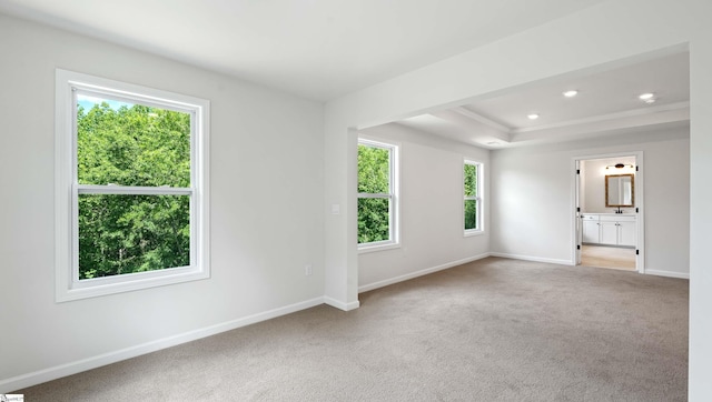 carpeted empty room featuring baseboards, a raised ceiling, and recessed lighting