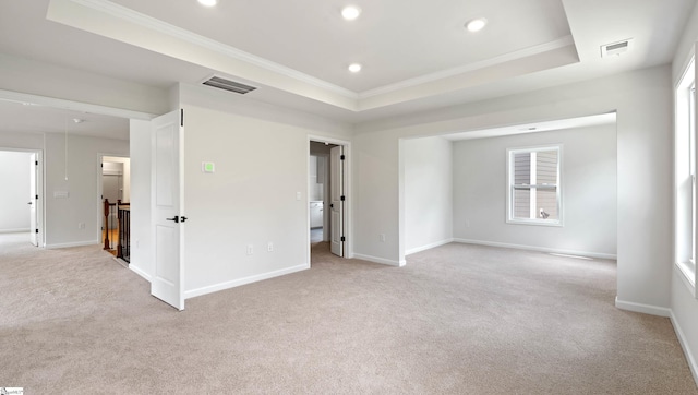 unfurnished bedroom with light carpet, crown molding, baseboards, recessed lighting, and a tray ceiling