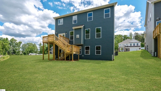 back of property featuring stairs, a wooden deck, a lawn, and central AC unit