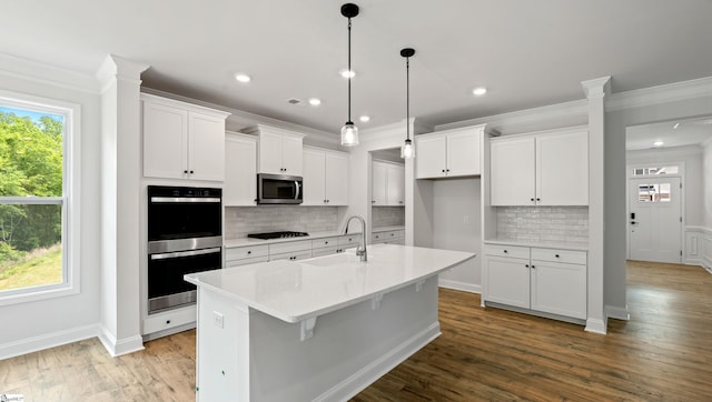 kitchen featuring appliances with stainless steel finishes, plenty of natural light, white cabinets, crown molding, and recessed lighting