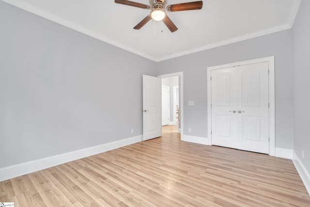 unfurnished bedroom with ceiling fan, a closet, light wood-type flooring, and crown molding