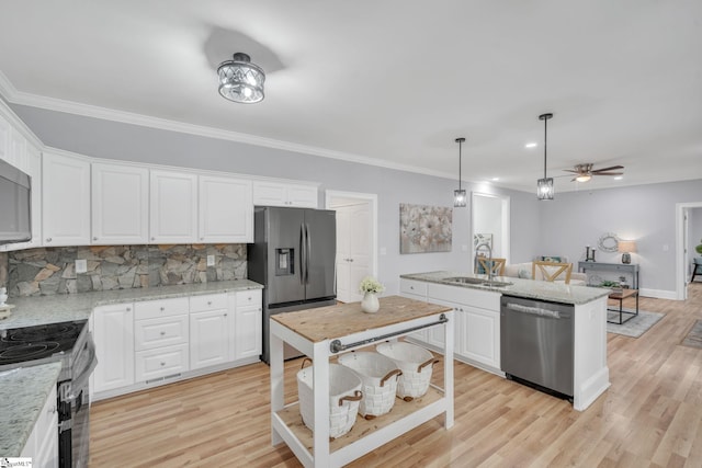 kitchen featuring stainless steel appliances, light hardwood / wood-style floors, a center island with sink, and white cabinetry