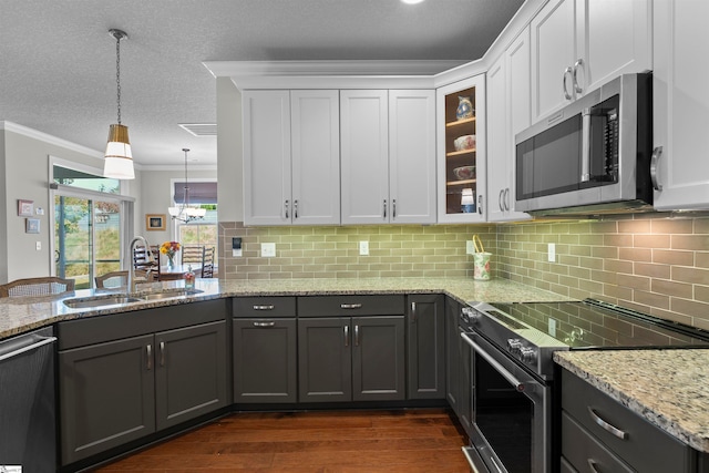 kitchen featuring stainless steel appliances, dark hardwood / wood-style flooring, sink, ornamental molding, and white cabinetry