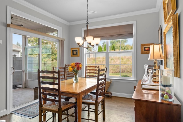 dining room featuring ornamental molding, light hardwood / wood-style flooring, a chandelier, and plenty of natural light