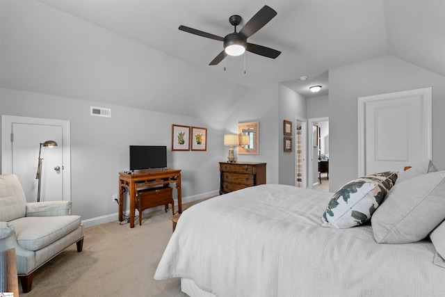 bedroom with ensuite bathroom, light colored carpet, ceiling fan, and vaulted ceiling