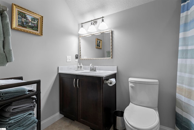 bathroom with tile patterned flooring, vanity, a textured ceiling, and toilet