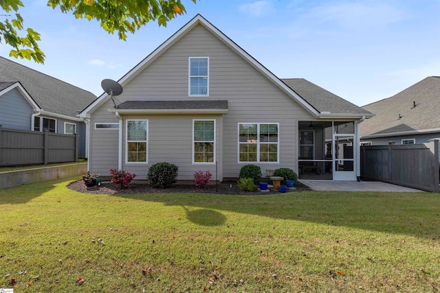 back of house with a yard, a sunroom, and a patio area