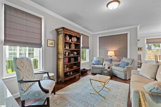 living room with dark wood-type flooring, a textured ceiling, crown molding, and plenty of natural light