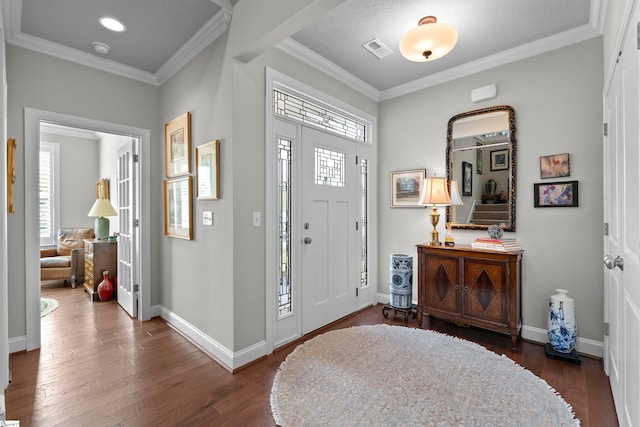 entrance foyer with dark hardwood / wood-style flooring, a textured ceiling, and crown molding