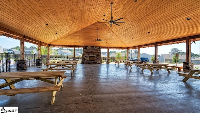 unfurnished sunroom featuring ceiling fan, vaulted ceiling, and wooden ceiling