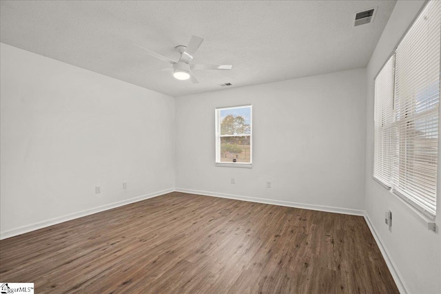 spare room with dark wood-type flooring, ceiling fan, and a textured ceiling