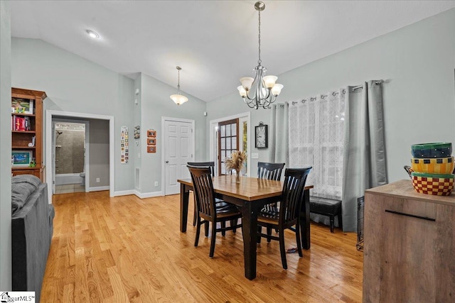 dining space featuring an inviting chandelier, vaulted ceiling, and light hardwood / wood-style floors