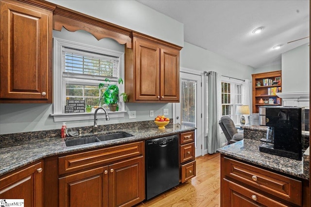 kitchen with dishwasher, light wood-type flooring, sink, and dark stone countertops