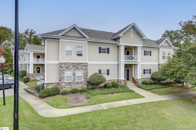 view of front of home featuring a front yard and a balcony