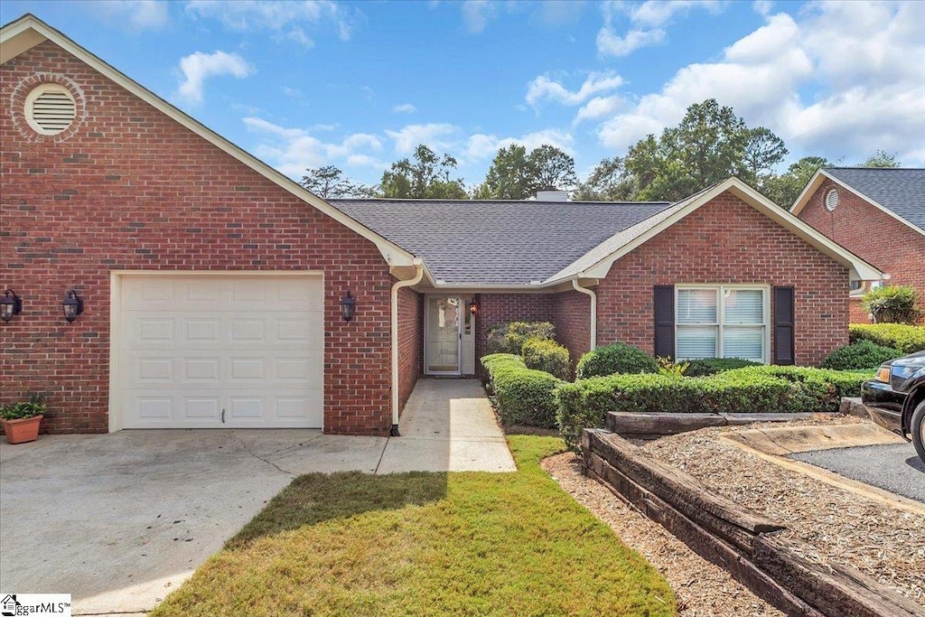 single story home featuring a garage and a front lawn