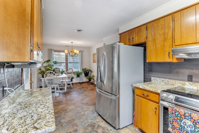 kitchen featuring stainless steel appliances, light stone counters, a chandelier, decorative backsplash, and exhaust hood