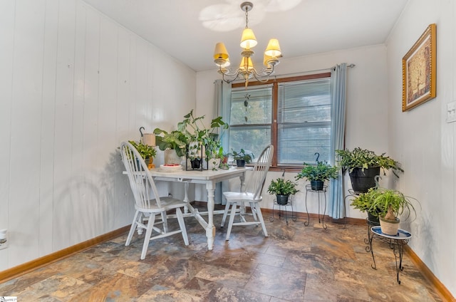 dining space featuring wood walls and a chandelier