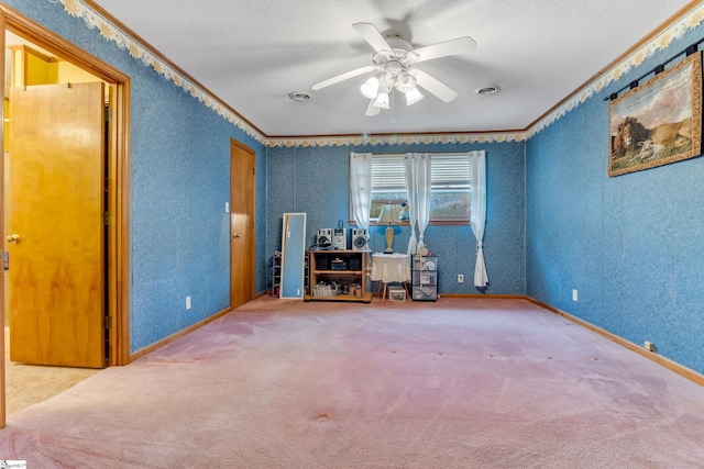 interior space with ornamental molding, a textured ceiling, carpet floors, and ceiling fan