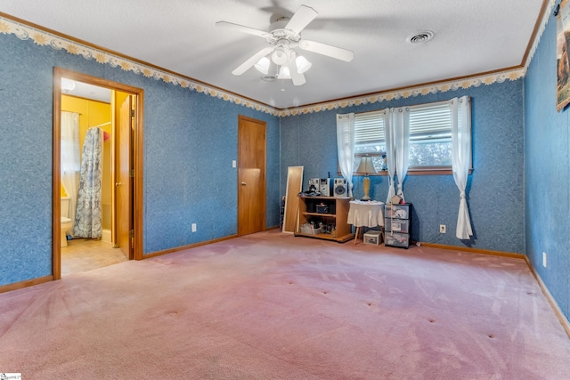 unfurnished bedroom with ensuite bathroom, ceiling fan, a textured ceiling, crown molding, and carpet floors