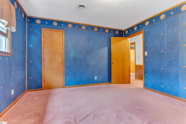 unfurnished room with a textured ceiling and carpet floors