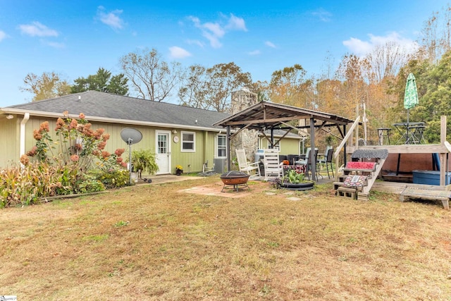 rear view of house featuring a yard, an outdoor fire pit, a gazebo, and a wooden deck