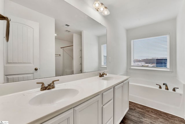 bathroom with hardwood / wood-style floors, vanity, and a tub to relax in