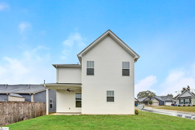 rear view of house featuring a yard and ceiling fan