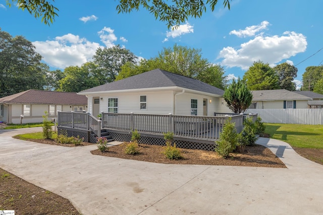 ranch-style home with a front lawn and a wooden deck