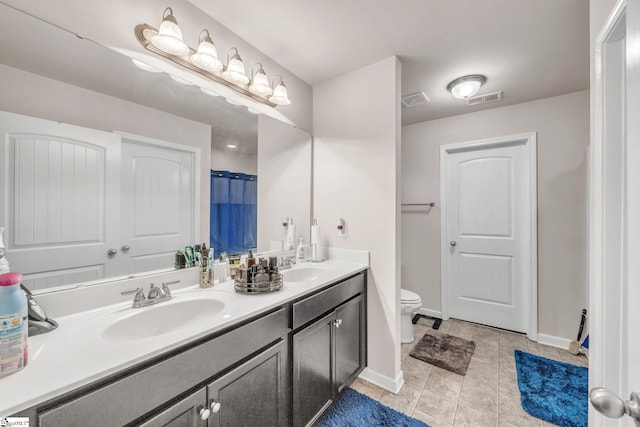 bathroom with tile patterned flooring, vanity, and toilet