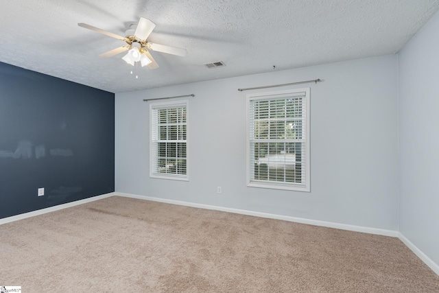 unfurnished room with ceiling fan, carpet floors, and a textured ceiling