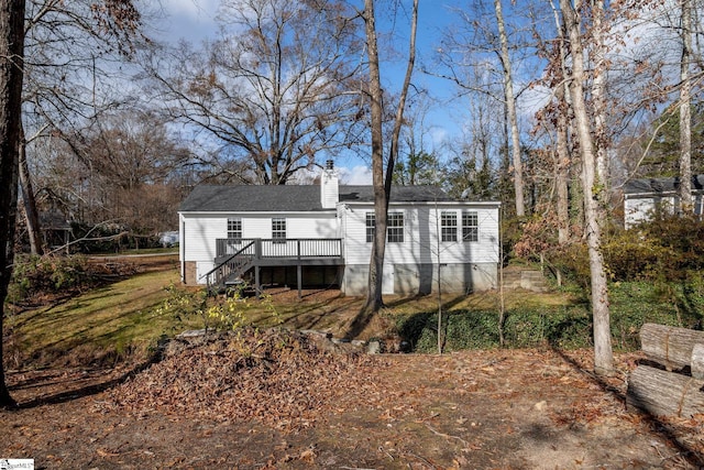 rear view of property featuring a wooden deck