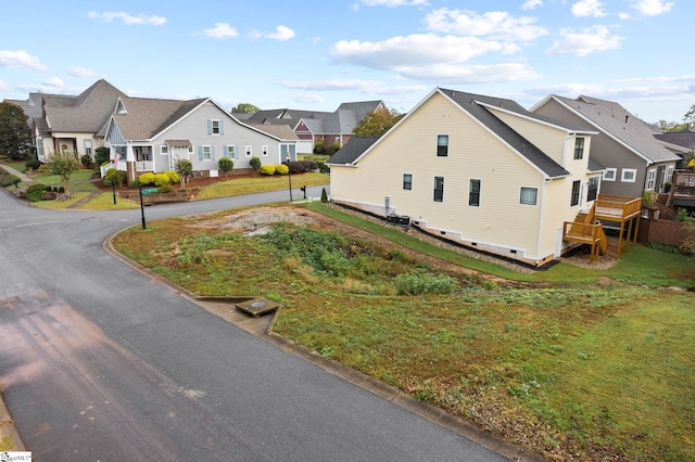 view of side of property with a wooden deck and a yard