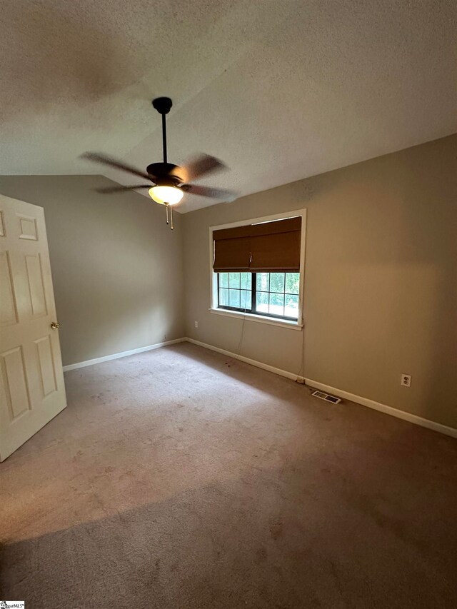 empty room featuring ceiling fan, a textured ceiling, and carpet floors