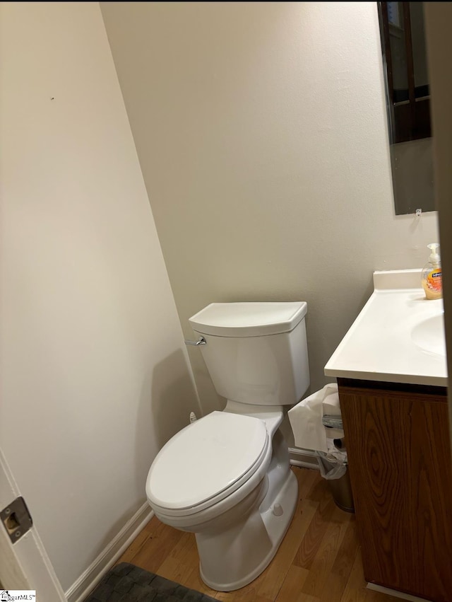 bathroom with hardwood / wood-style flooring, vanity, and toilet