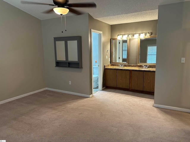 bathroom featuring vanity, ceiling fan, a textured ceiling, and toilet