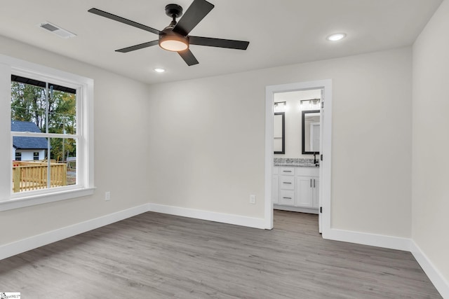 unfurnished bedroom with hardwood / wood-style floors, ceiling fan, and connected bathroom