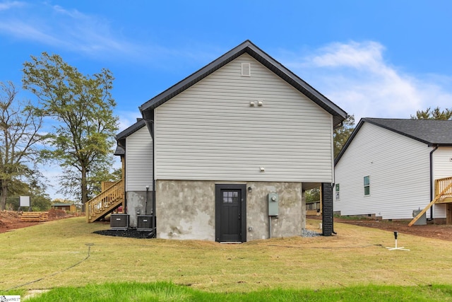 rear view of property with a lawn and cooling unit